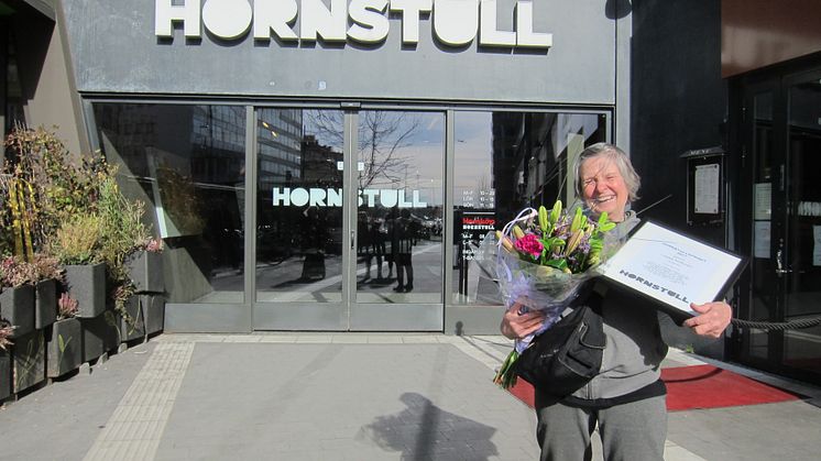 Lilleba Huttunen tar emot utmärkelsen framför entrén till Hornstulls handelsplats 