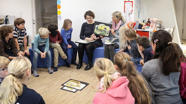 Karen Nehlsen (mitte rechts) liest aus dem plattdeutschen Buch "De Bremer Stadtmuskanten" vor.