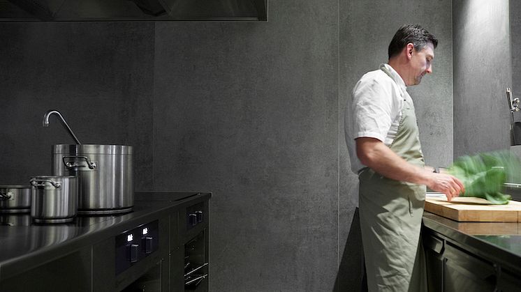 Eier og kjøkkensjef hos Ti Trin Ned, Rainer Gassner, i deres produksjonskjøkken med Dekton® by Cosentino på vegger og benker.