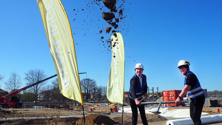 Johan Ericsson och Pia Almström tar det första spadtaget för Kävlinge kommuns nya badhus. I bakgrunden förbereds fundament för framtidens simbassänger. Harjagersbadet kommer bli ett badhus på tre våningar med något för alla.