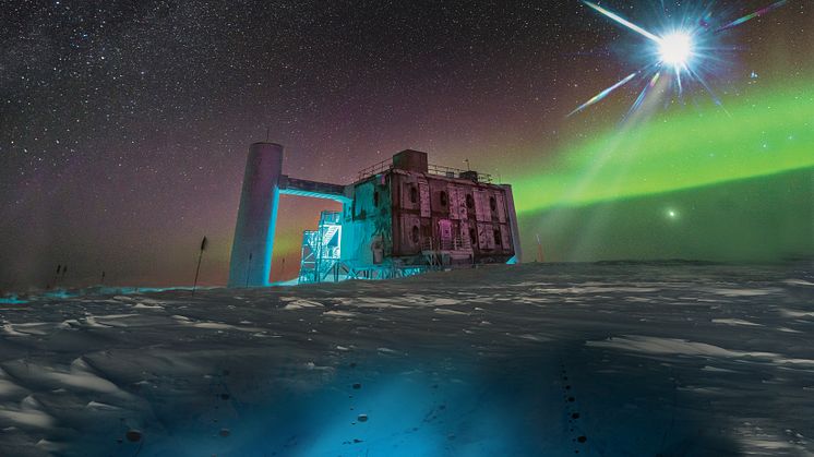 I denna konstnärliga bild, som utgår från ett foto av IceCube Lab vid Sydpolen, avger en avlägsen källa neutriner som detekteras under isen av IceCube-sensorer. Foto: Icecube / NSF