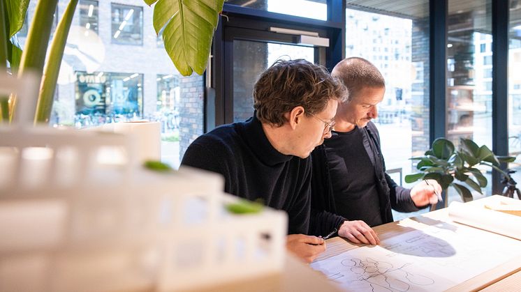 Det nye byrum- og landskabsteam sidder til dagligt i AARTs kontor i Pakhusene på Aarhus Ø. På billedet ses faglig leder Jens Byriel Kinch (th.) i skitserende dialog med en kollega.