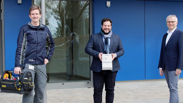 Michael Schindler (l.) und Stephan Leibl (r.) von der Bayernwerk Netz haben mit Bürgermeister Raffael Parzefall in der Grundschule Thalmassing einen intelligenten Zähler montiert. Deutschlandweit im E.ON-Konzern ist es der 100.000 Smart Meter.