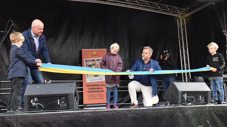 Elev och Niklas Wikström (L) klipper invigningsbandet