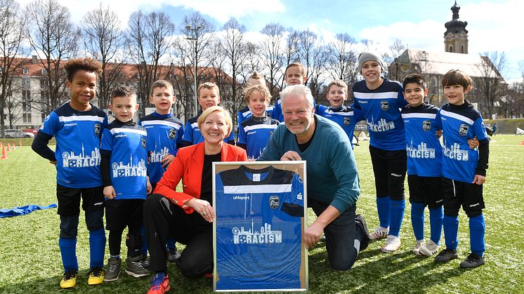 Sabine Schölzel (Vorständin Stadtsparkasse München), Michael Franke (1. Vorsitzender FT Gern) und die U7-Fußballmannschaft der FT Gern freuen sich über die neuen Trikots.