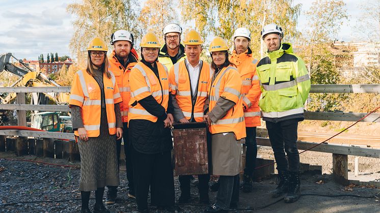 Representanter från Skellefteå kommun, Arctic Center of Energy och Peab håller i tidskapseln på byggplatsen för ACE-huset. Foto: Jonas Westling. 
