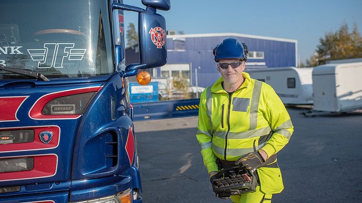 Lastbilsföraren Niklas Jansson hanterar en fordonsmonterad kran.