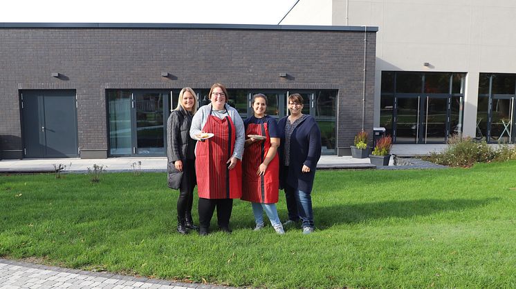 Auf der Terrasse am Kultur- und Bürgerzentrum Neustadt soll es am Sonntag Kaffee und Kuchen geben. Tamara Lohse, Anne Günther, Sude Karadagli und Tanja Keller (von links) freuen sich auf die Besucher*innen. Foto: Melanie Schmitt.