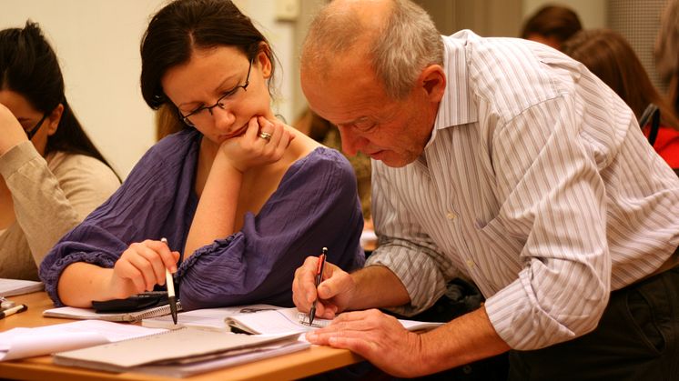 Volontär och elever försöker lösa ett matematiskt problem under Mattecentrums räknestuga