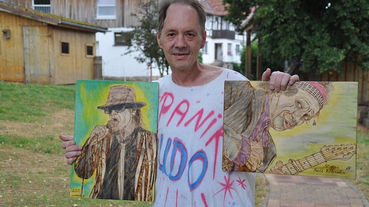 Udo-Lindenberg-Fan Jörg Ernst Brück in seinem Lieblings-T-Shirt zeigt zwei seiner in Holzbrandtechnik geschaffenen Bilder von „Panik-Udo“ und Keith Richards.