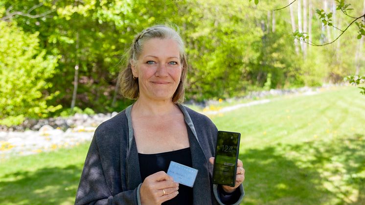 Anita Vasstveit med sitt første utfylte Donorkort™ og den nyeste appen på telefonen.