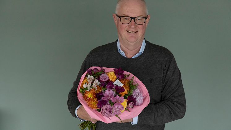 Erling Ølstad viser stolt fram årets bukett som både har støttet Rosa sløyfe-aksjonen og Fairtrade prosjekter.