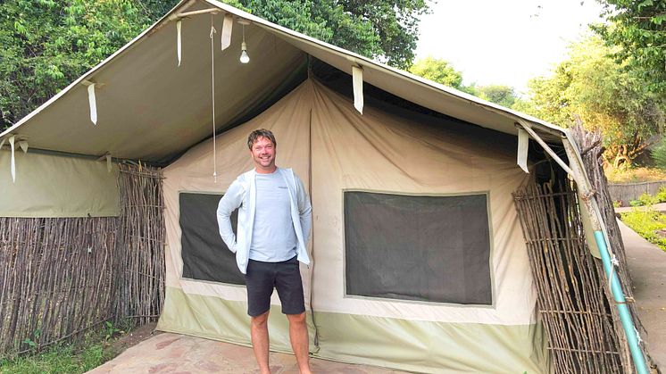 Verksamhetschefen Jonas Sommar framför ett tält i viltreservatet Masai Mara.
