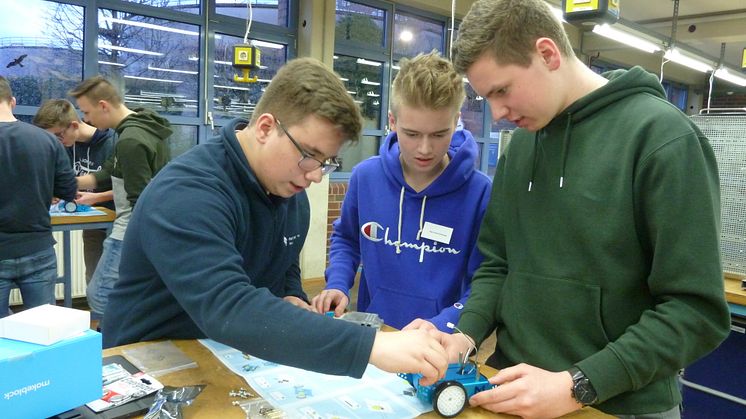 WWE- Azubi Jan Niklas Heidemann, Finn Levin Schmude und Mathis Stratmann vom Delbrücker Gymnasium bauen beim Energy Camp einen Mini-Roboter in der Ausbildungswerkstatt. (v. l.).