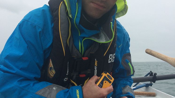 Carbon Zerow rower Kyle Smith with one of the Ocean Signal rescueME PLB1s 