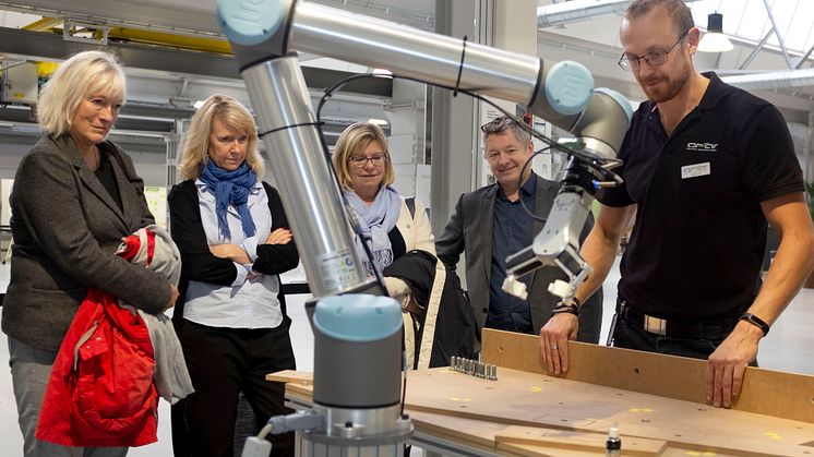 Högskolan i Skövdes styrelse besöker innovationsmiljön ASSAR. Styrelsens ordförande Kerstin Norén, ledamoten Pia Kronqvist, prorektor Lena Mårtensson och rektor Lars Niklasson tittar medan Niklas Land beskriver hur en kollaborativ robot arbetar.