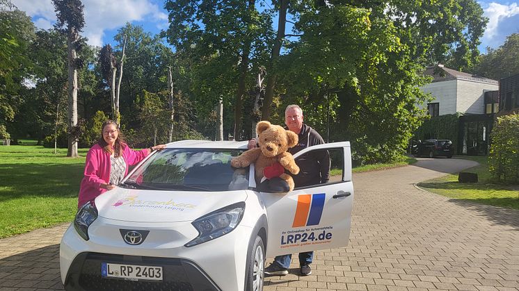 Ulrike Herkner und Michael Meinel präsentieren stolz das neue Auto vor dem Kinderhospiz Bärenherz