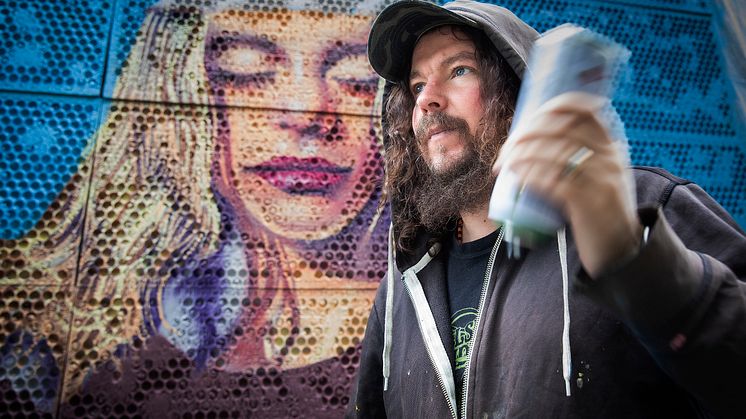 Charlie Granberg framför muralmålningen