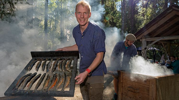 Fiskerøyking er et tradisjonsrikt innslag som bokstavelig talt faller i smak hos gjestene på De nordiske jakt- og fiskedagene. Erik Burud er røykemester. (Foto: Bård Løken/Anno Norsk skogmuseum)