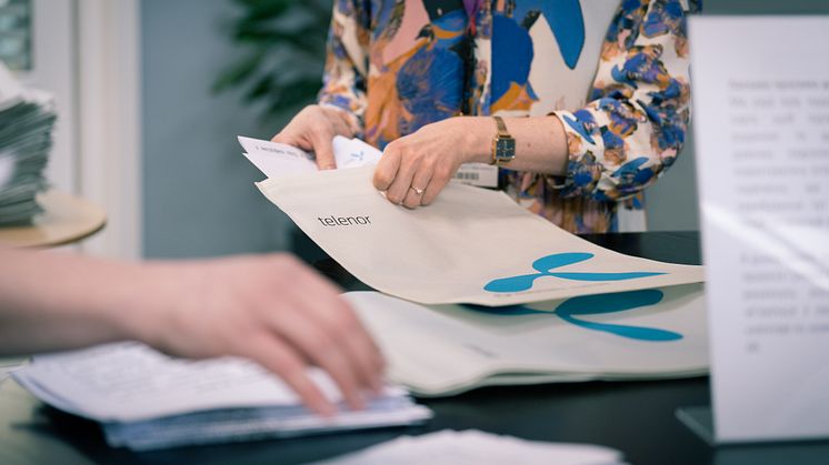 Telenor-medarbejdere hjælper med at pakke SIM-kort