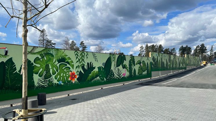 Spännande djur och färgglad grönska sätter färg på tillvaron intill Wallenstams nybyggnation Parkstråket vid Örnens väg i Haninge. Där monteras en 107 meter lång muralmålning på ett byggplank för att bidra till en trevlig utsikt för de nyinflyttade.