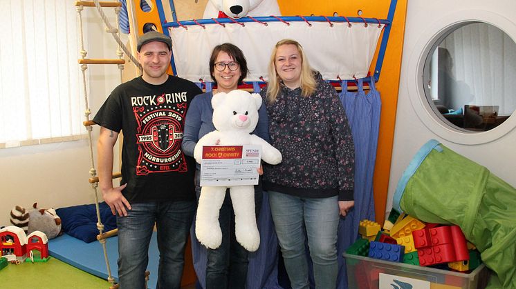  Philip Berg, Kerstin Stadller vom Kinderhospiz und die Schatzmeisterin des Vereins "Rock 4 Charity", Heike Heller, präsentieren stolz den Spendenscheck im Spielzimmer des Kinderhospizes