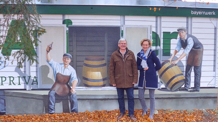 Ein weiteres Original aus Aying: Bürgermeister Johann Eichler (l.) und Bayernwerk-Kommunalbetreuerin Silke Mall (r.) stellen am Bahnhof die von ART-EFX zu einem historischen Güterwagon umgestaltete Trafostation der Öffentlichkeit vor.