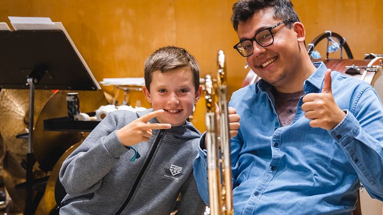 En deltagare i musiklägret Side by Side 2022 bredvid trombonisten Arno Tri Pramudia från Göteborgs Symfoniker.