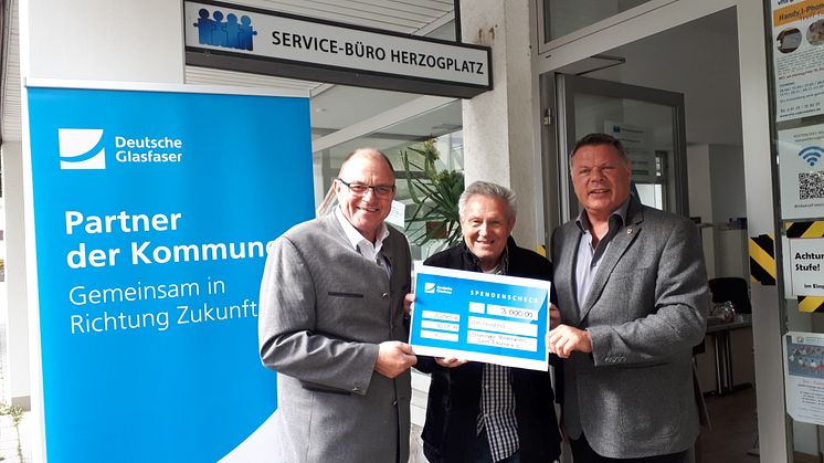 Peter Reisinger (Deutsche Glasfaser, links) übergab den symbolischen Scheck an Vereinsvorstand Gerhard Wolf (mittig) und Bürgermeister Piet Mayr.