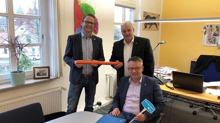 Bürgermeister Andreas Wittenberg hat einen Vertrag für einen echten, kupferfreien Glasfaseranschluss unterzeichnet. Dahinter: Tjark Hartmann (links) und Stefan Teutscher von Deutsche Glasfaser.