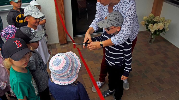 Kitaleiterin Frau Köpke schneidet zur Kitaeröffnung ein Band durch. Foto: Pressestelle LK Barnim/Oliver Köhler
