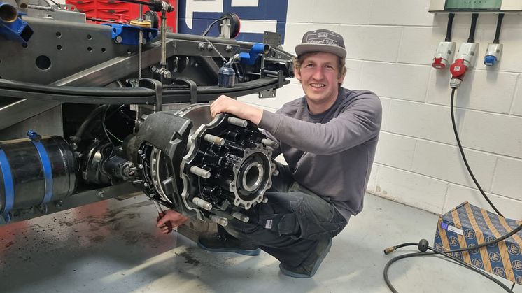 T Sport Bernau Cheftechniker Tim Frost bei Arbeiten an der Bremse des Renntrucks.  