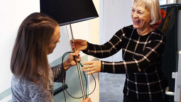 Glada grannar delar en lampa