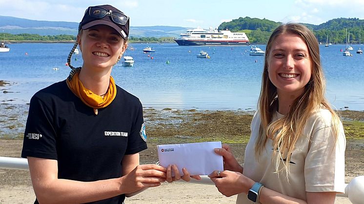 Vivi Bolin, Science & Education Coordinator on board MS Maud, presents Caroline with the donation_Credit_Hebridean Whale and Dolphin Trust