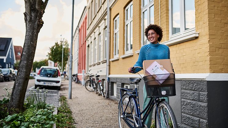 Kvinde med cykel afhenter GLS pakker