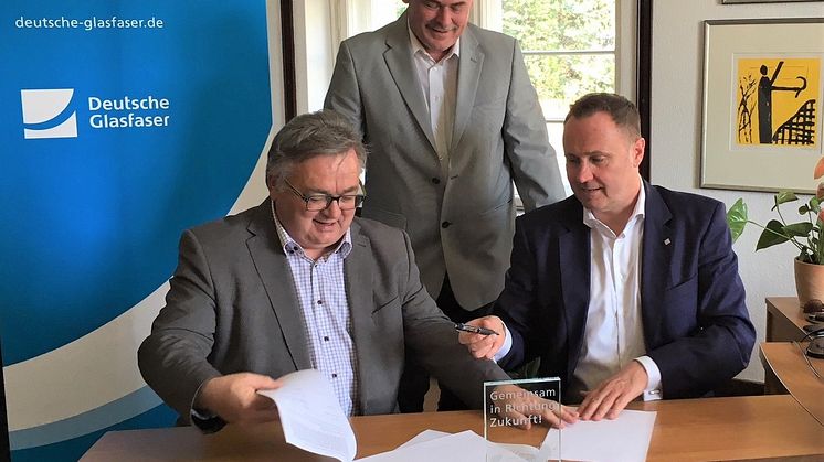 Ludwig Martin, Bürgermeister der Gemeinde Borsdorf (links) Michael Kölling, Regional Manager Deutsche Glasfaser Mitteldeutschland (rechts) und Projektmanager FttH Mitteldeutschland (hinten) besiegeln die Zusammenarbeit für den Glasfaser-Ausbau. (DG)