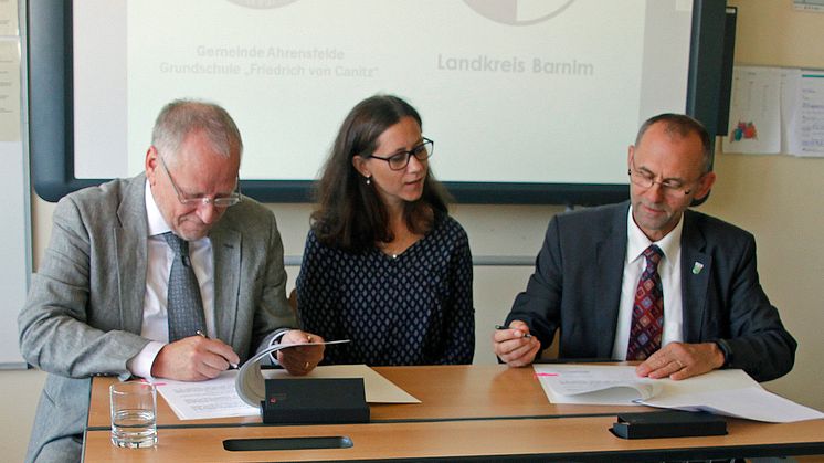 Unter den Augen von Schulleiterin Patricia Franke unterzeichnen Landrat Bodo Ihrke (l.) und Bürgermeister Wilfried Gehrke die Vereinbarung. Foto: Oliver Köhler