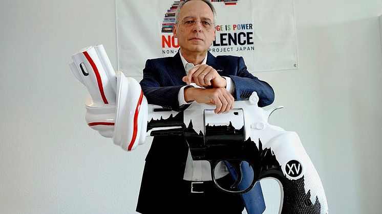 Blaise Oberson, CEO of The Non-Violence Project Foundation, together with a designed version of the knotted gun sculpture