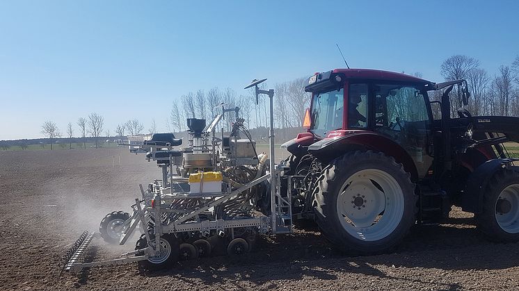 Traktor sprider den torkade växtnäringen