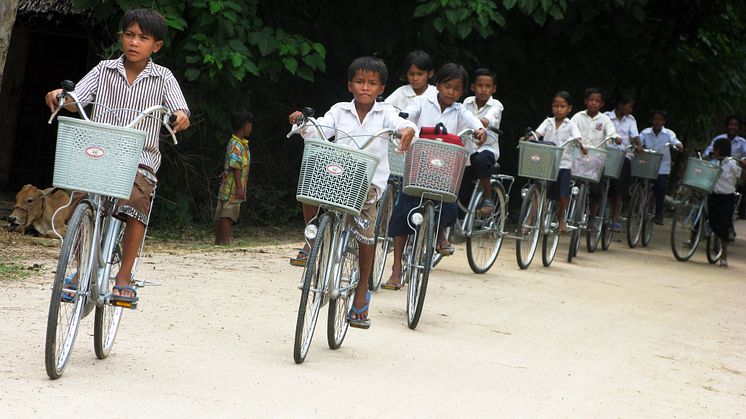 Kambodjanska skolbarn på cykel
