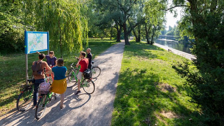Mit dem Rad durch das Grün der Stadt fahren.