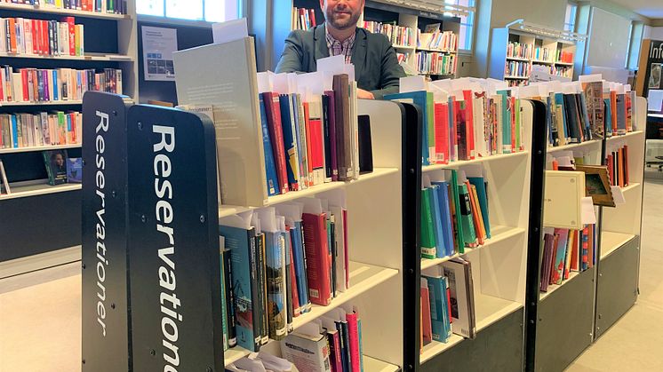 Kultur- och stadsmiljöborgarråd Jonas Naddebo (C) vid Stadsbibliotekets reservationshylla
