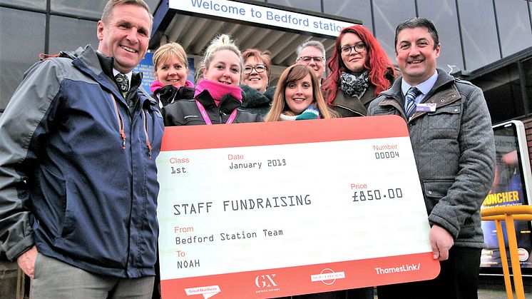Jim O'Connor MBE, NOAH Enterprise Chief Executive (left) accepts the £850 donation from Bedford Station Manager Joe Healy (right) and the Thameslink bake sale team