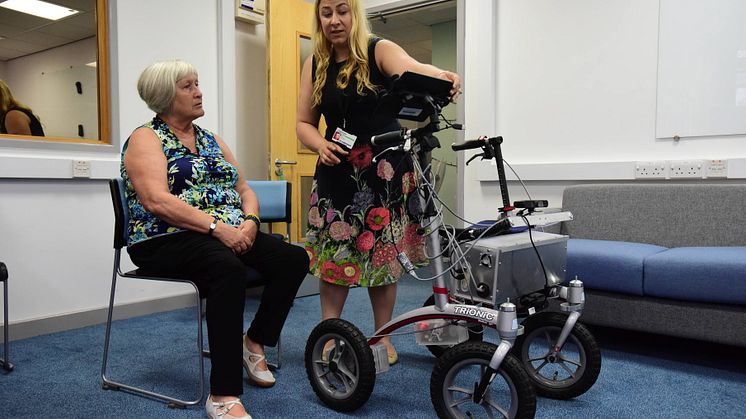 Volunteer Pauline being shown how to use the robotic walker by researcher Mia Campbell from Northumbria's PaCT Lab