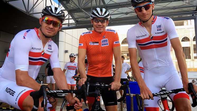 Laksetrøya skal være synlig under VM i Bergen 2017. Her står nestleder i Sjømatråd-styret, Sverre Søraa (i midten), sammen med landslagsprofilene Alexander Kristoff (til venstre) og Sven Erik Bystrøm. Foto: Norges Cykleforbund