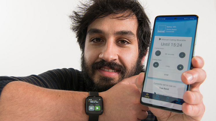 Senior Research Assistant Luís Carvalho pictured wearing the Cue Band, with the accompanying app displayed on his phone