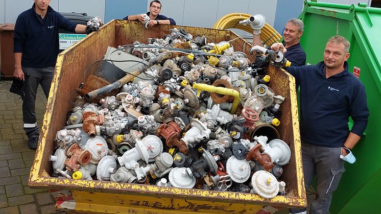 Das Ergebnis allein eines Arbeitstages im Überflutungsgebiet: ein Container voll mit Reglern, Zählern, Rohren. (v. l.) Mario Tölle (Bad Wünnenberg), Sascha Stümmler (Delbrück), Andreas Wigge (Bad Wünnenberg) und Matthias Göhre (Lage).