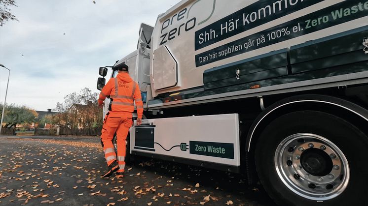 Chaufför går in i eldriven sopbil