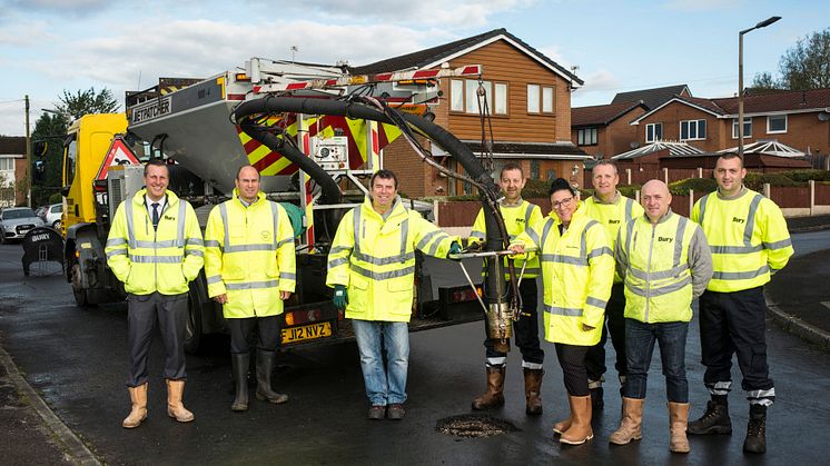Cllr Alan Quinn and interim chief executive Pat Jones-Greenhalgh (centre) join the highways team with the kind of spray injection patching machine the council is now buying. 