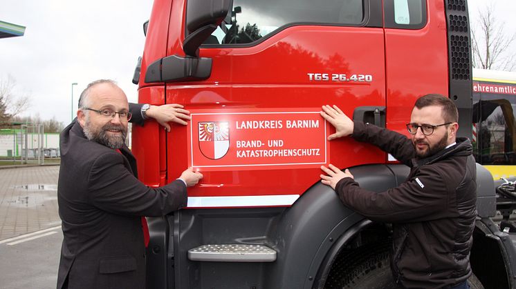 Barnims Landrat Daniel Kurth (l.) und BDG-Geschäftsführer Christian Mehnert bei der Übergabe des neuen Wechselladers. Foto: Pressestelle LK Barnim/Oliver Köhler
